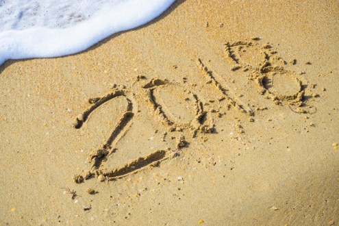 Abstract 2018 on a beach sand background